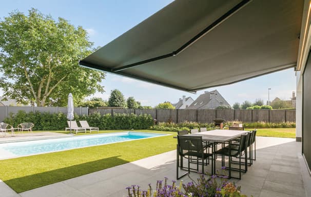 Terras met zwembad en geopend Wilms zonnescherm